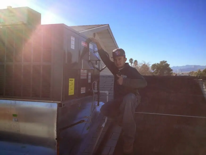 HVAC technician performing Air Duct Repair on a rooftop unit in Signal Hill